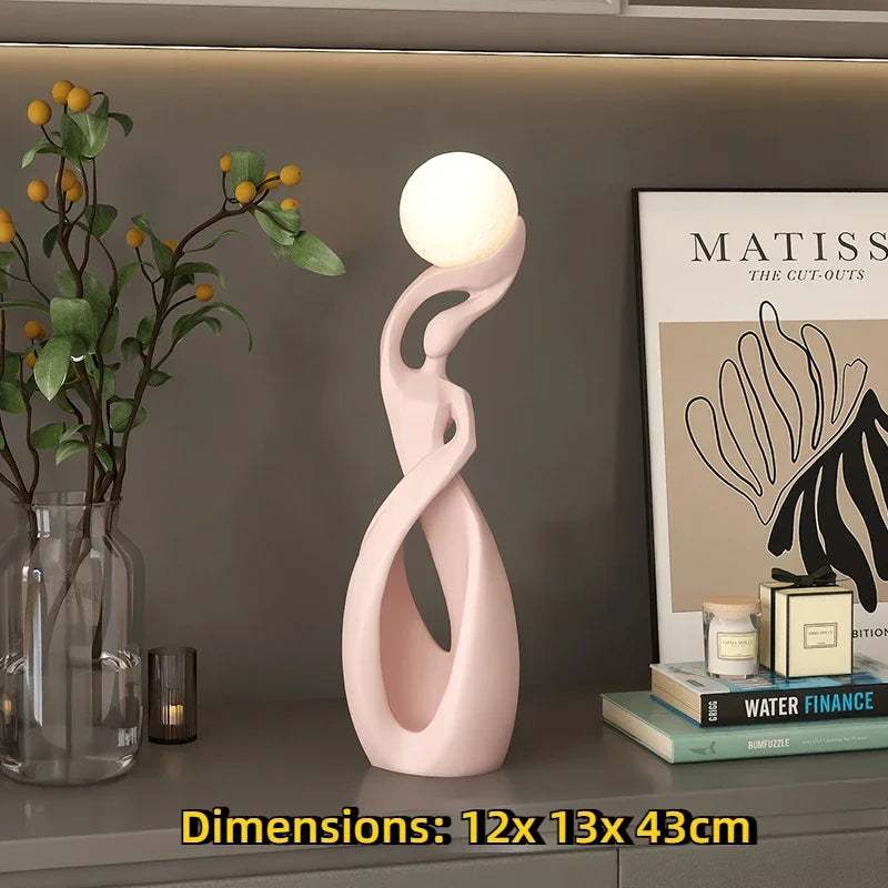 Home Decoration Resin Sculpture LED floor lamp in pale pink resin, with an intertwined abstract figure and glowing orb shade.