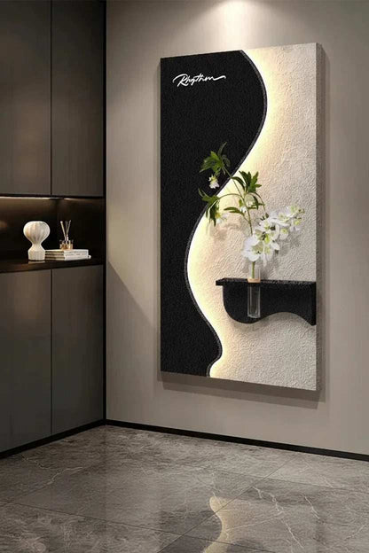 Green Plant LED Wall Lamp with black and cream sculptural panels, a curved illuminated edge, and an ornamental green plant with white flowers