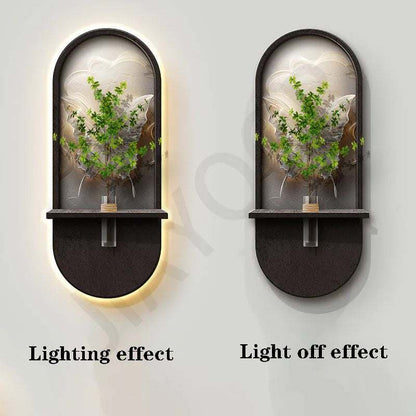Green Plant Wall Lamp with a black rounded frame, arched glass panel, and decorative green foliage, shown lit and unlit.