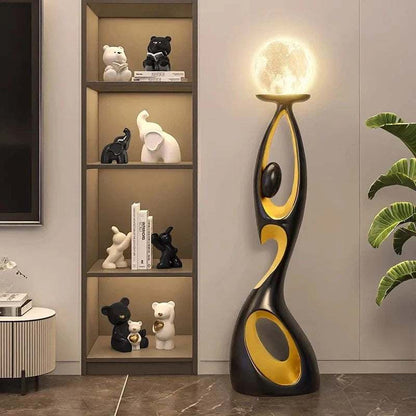 LED Floor Lamp Non Dimmable with a sculptural black metal base, gold accents, oval cutouts, and glowing spherical bulb