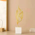 Nordic Ceramic Statue with a white ribbed ceramic base and slender gold metal wire sculpture in an abstract leaf shape.