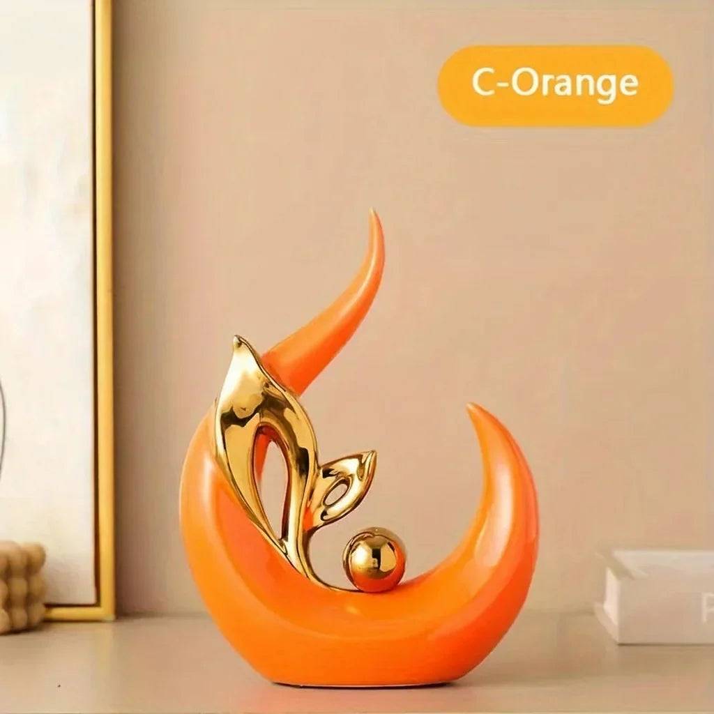 Nordic Ceramic Statue in glossy orange ceramic, with a curved crescent form and gold-tone leaf accents and sphere.